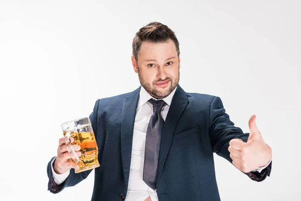 Пухкий чоловік в офіційному одязі тримає келих пива і показує великий палець вгору ізольовано на білому — стокове фото