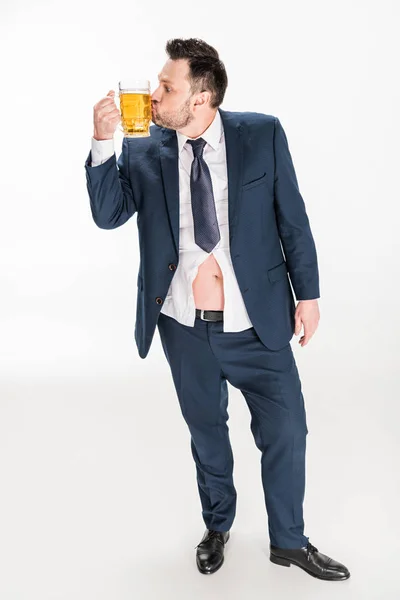 Homem com sobrepeso no desgaste formal beijando vidro de cerveja no branco — Fotografia de Stock