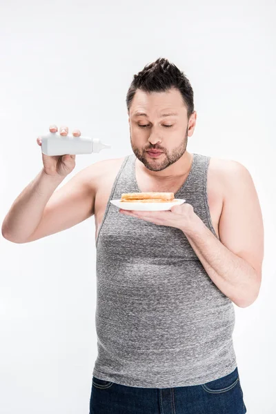 Overweight man holding bottle of syrup and waffles isolated on white — Stock Photo