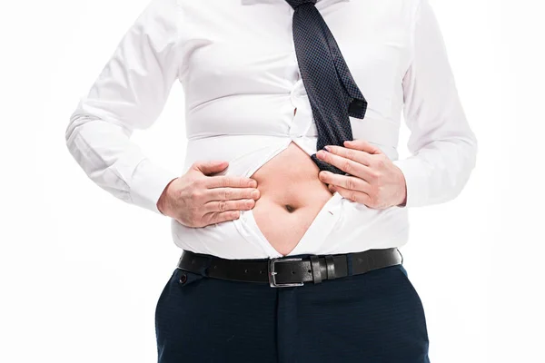 Vista parziale di sovrappeso uomo in stretto abbigliamento formale mostrando pancia isolata su bianco — Foto stock