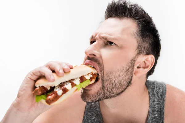 Übergewichtiger bärtiger Mann isst Hot Dog isoliert auf weiß — Stockfoto