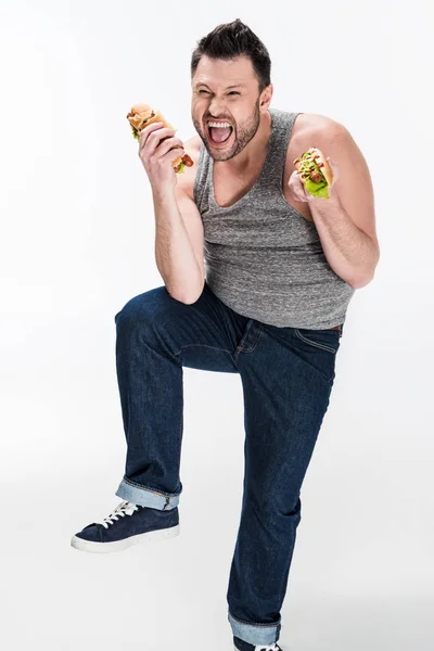 Excited overweight man holding hot dogs on white — Stock Photo