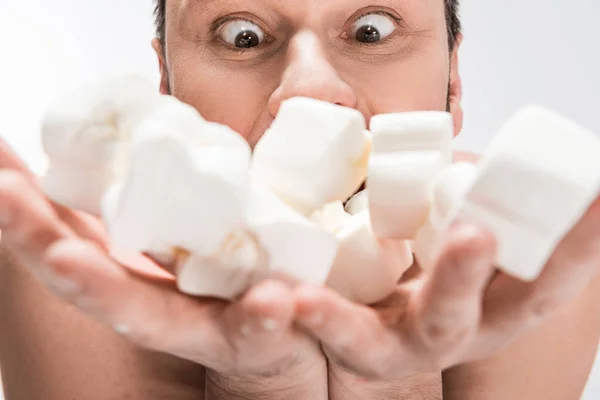 Selective focus of excited man holding marshmallows isolated on white — Stock Photo