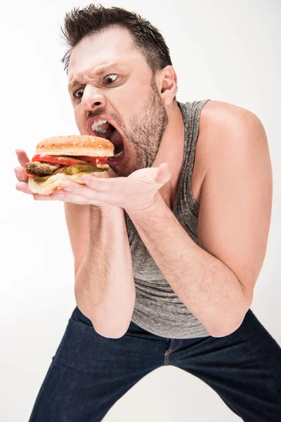 Homem com sobrepeso fazendo expressão facial enquanto posando com hambúrguer no branco — Fotografia de Stock