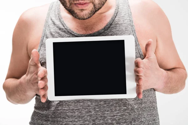Abgeschnittene Ansicht eines übergewichtigen Mannes, der ein digitales Tablet mit leerem Bildschirm zeigt, isoliert auf weiß — Stockfoto
