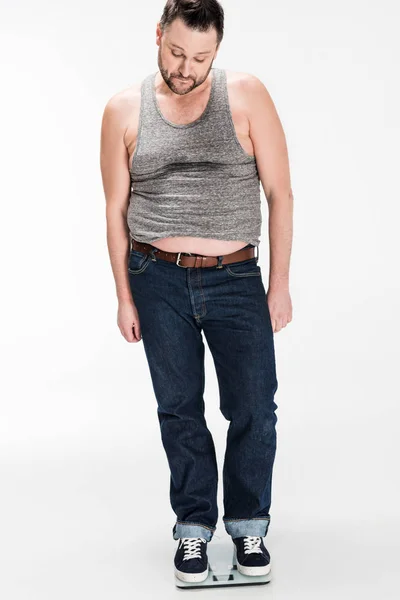 Homem com sobrepeso em pé em balanças de peso eletrônico isolado em branco — Fotografia de Stock