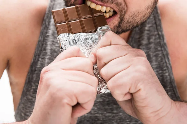 Vue recadrée d'homme potelé mangeant du chocolat isolé sur blanc — Photo de stock