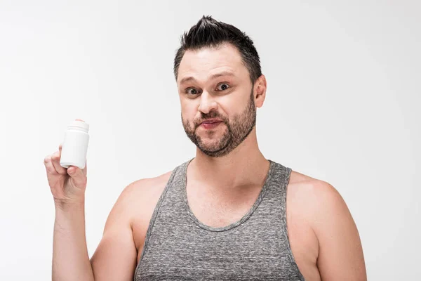 Hombre con sobrepeso sosteniendo frasco de medicina y mirando a la cámara aislada en blanco - foto de stock