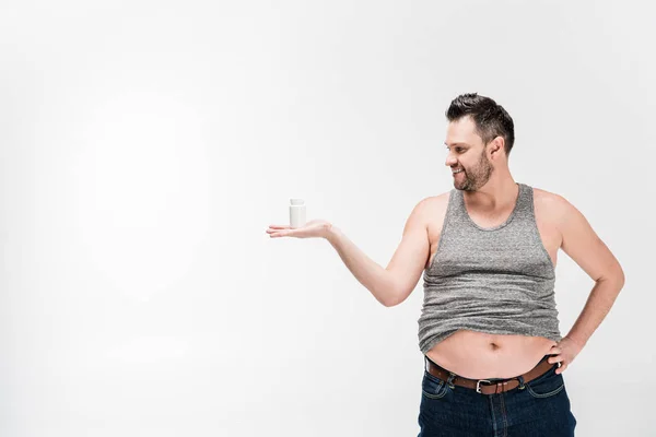Übergewichtiger Mann hält Flasche mit Medikamenten auf weiß mit Kopierplatz — Stockfoto