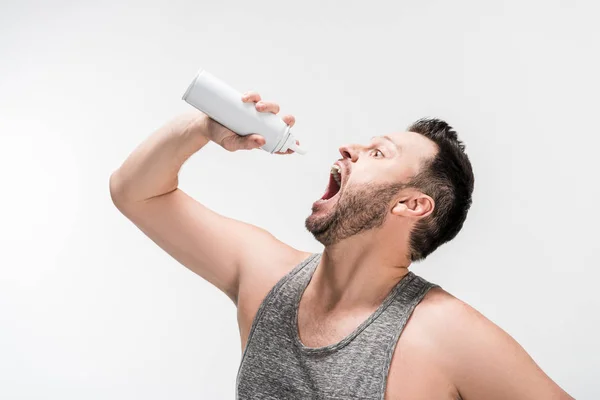 Пухкий чоловік з відкритим ротом тримає пляшку збитих вершків ізольовано на білому — стокове фото