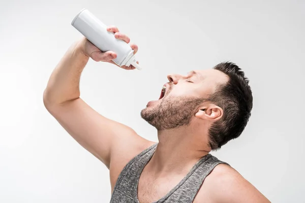 Gordito hombre con boca abierta celebración botella de crema batida en blanco - foto de stock