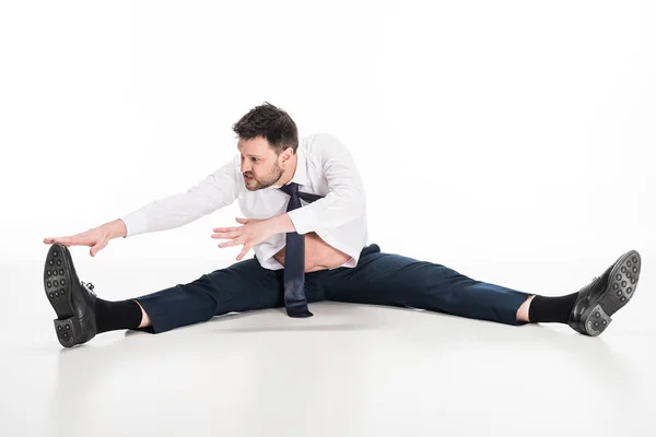 Overweight man in tight formal wear sitting and stretching on white — Stock Photo