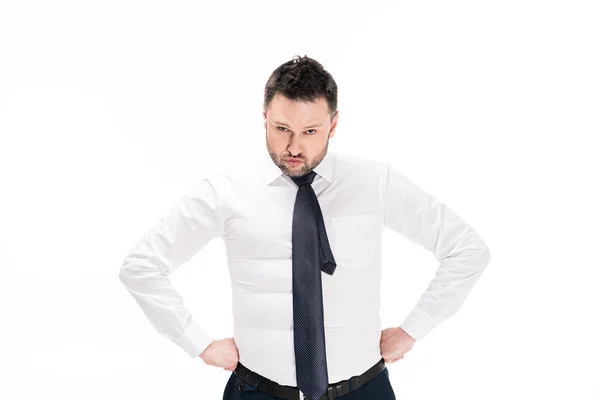 Overweight man in tight formal wear with hands akimbo looking at camera isolated on white — Stock Photo