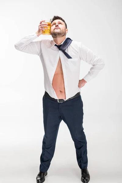 Homem com excesso de peso segurando vidro de cerveja perto do rosto no branco — Fotografia de Stock