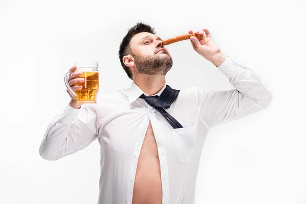 Homem com sobrepeso com olhos fechados cheiro aroma de salsicha e segurando vidro de cerveja isolado em branco — Fotografia de Stock