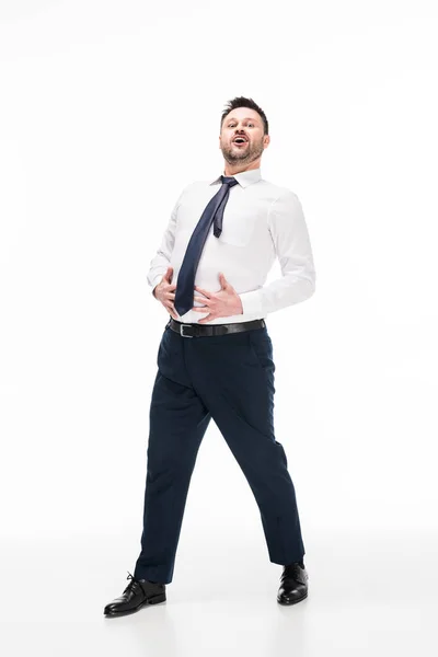 Pummeliger Mann in formaler Kleidung, der in die Kamera blickt und Bauch auf Weiß berührt — Stockfoto