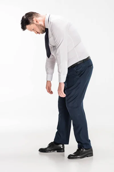 Overweight man in tight formal wear bending over on white — Stock Photo