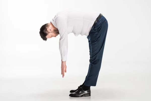 Надмірна вага людини в жорсткому формальному носінні, що згинається і тягнеться на білому — стокове фото