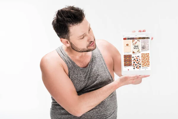 Overweight man showing digital tablet with pinterest app on screen isolated on white — Stock Photo