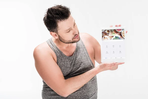 Sovrappeso uomo mostrando tablet digitale con app quadrata sullo schermo isolato su bianco — Foto stock