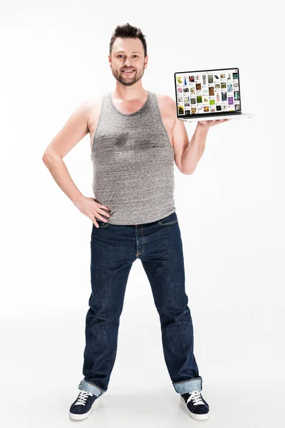 Улыбающийся человек с избыточным весом смотрит в камеру и представляет ноутбук с pinterest сайт на экране изолированы на белом — стоковое фото