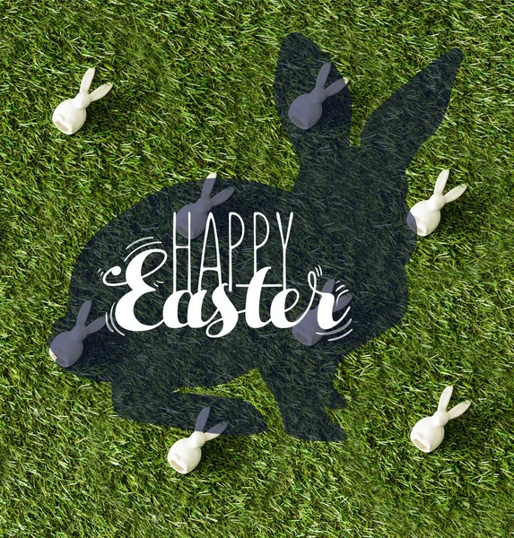 Vista superior de coelhos decorativos na grama verde com letras felizes Páscoa — Fotografia de Stock