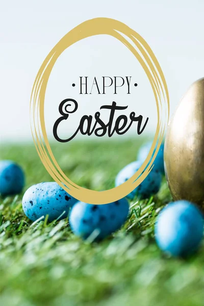 Blue painted quail eggs on green grass near golden chicken egg and happy Easter lettering in circle — Stock Photo