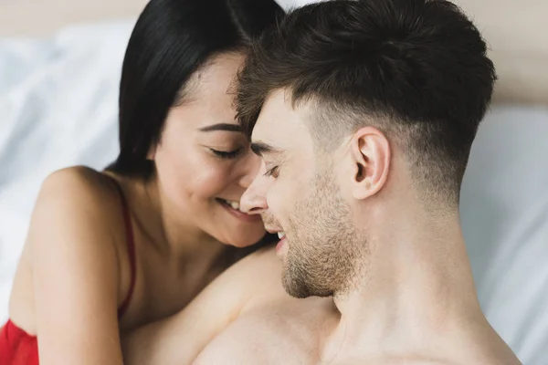 Hermosa, feliz asiático mujer abrazando guapo sonriente novio - foto de stock