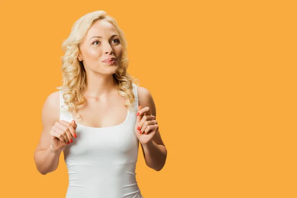 Femme blonde et bouclée debout en t-shirt blanc isolé sur orange — Photo de stock