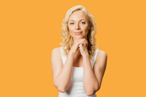 Beautiful woman looking at camera and standing with clenched hands isolated on orange — Stock Photo