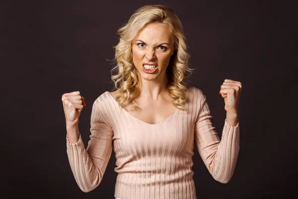 Wütende blonde Frau blickt in die Kamera und zeigt Fäuste isoliert auf schwarz — Stockfoto