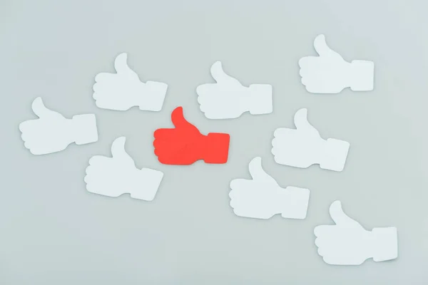 Red and white sticky notes with thumbs up shapes isolated on grey — Stock Photo