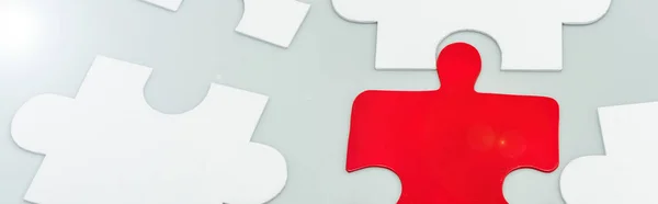 Panoramic shot of red and white jigsaw pieces on grey — Stock Photo
