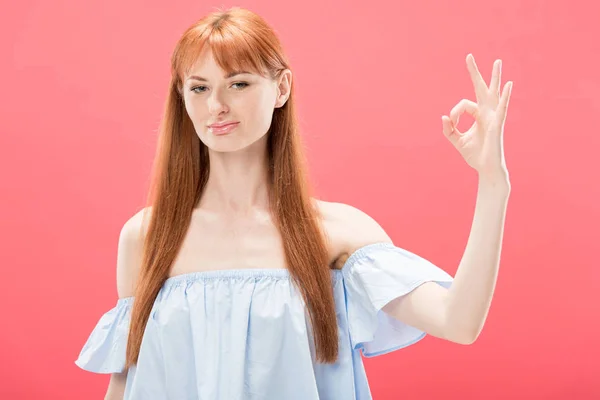 Confident redhead girl showing okay sign and looking at camera isolated on pink — Stock Photo
