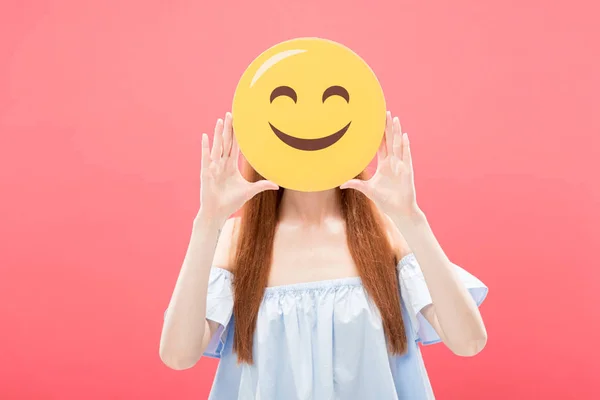 KYIV, UKRAINE - MAY 23, 2019: front view of redhead girl holding smiley isolated on pink — Stock Photo