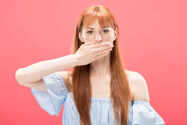 Front view of serious redhead girl covering mouth with hand and looking at camera isolated on pink — Stock Photo