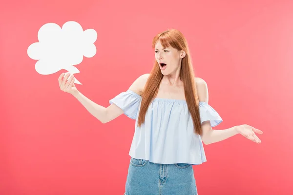 Irritated redhead young woman holding empty thought bubble isolated on pink — Stock Photo