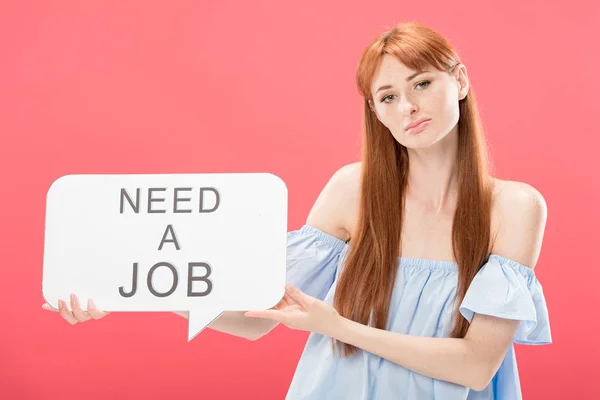 Sad redhead girl holding speech bubble with inscription need a job isolated on pink — Stock Photo