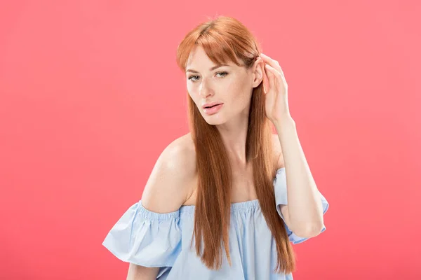 Sinnliches rothaariges Mädchen, das Haare berührt und isoliert auf rosa Kamera schaut — Stockfoto
