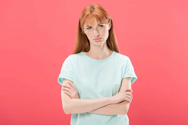 Front view of pensive redhead young woman in t-shirt standing with crossed arms isolated on pink — Stock Photo