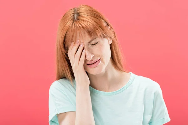 Vue de face de la jeune femme rousse en t-shirt avec maux de tête touchant la tête isolé sur rose — Photo de stock