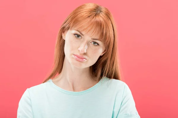 Front view of sad pensive redhead girl in t-shirt looking at camera isolated on pink — Stock Photo