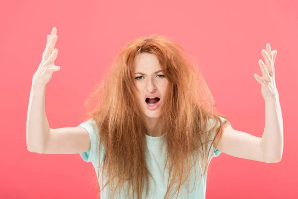 Femme rousse en colère avec les cheveux emmêlés agitant les mains isolées sur rose — Photo de stock