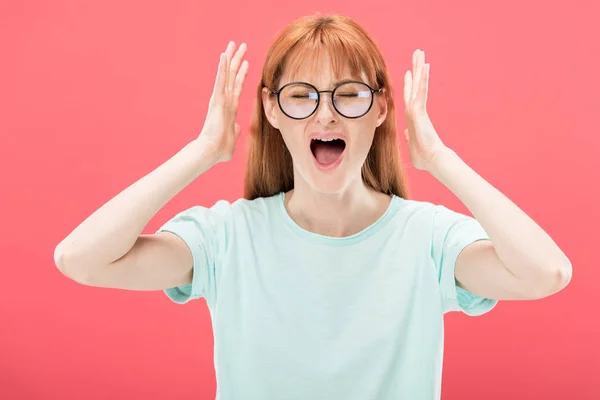 Vista frontal de mulher ruiva com raiva em óculos gritando com olhos fechados e t-shirt isolada em rosa — Fotografia de Stock