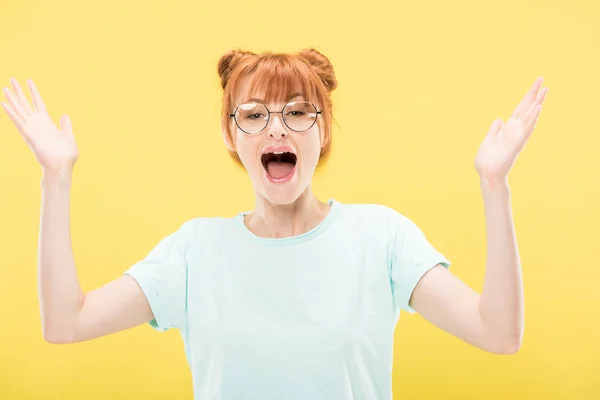 Heureux rousse fille en lunettes et t-shirt geste isolé sur jaune — Photo de stock