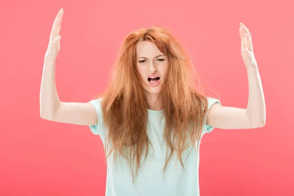 Femme rousse stressée avec les cheveux emmêlés agitant les mains isolées sur rose — Photo de stock