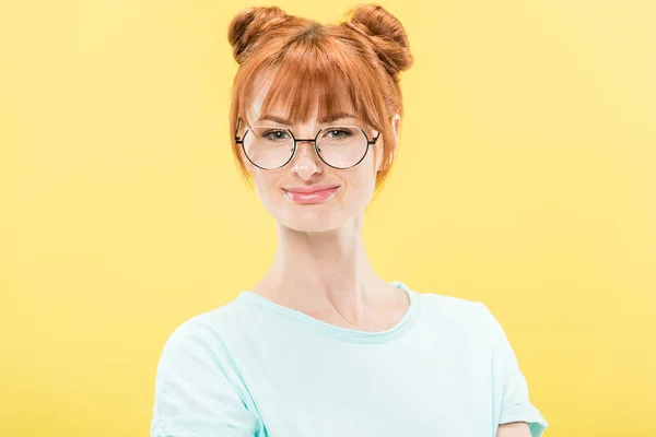 Front view of smiling redhead girl in glasses and t-shirt looking at camera isolated on yellow — Stock Photo