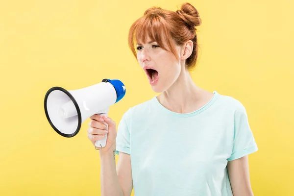 Raiva ruiva jovem mulher segurando megafone e gritando isolado no amarelo — Fotografia de Stock