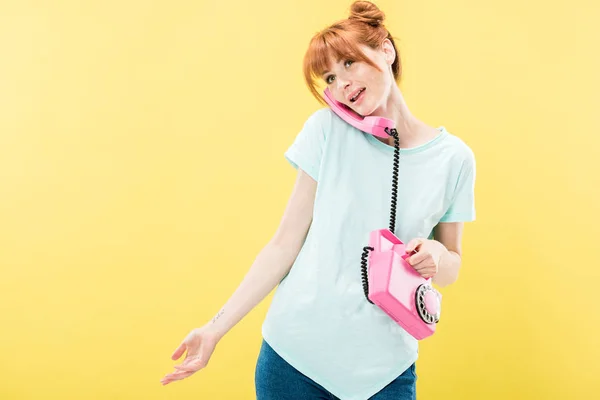 Attractive redhead young woman talking on retro telephone isolated on yellow — Stock Photo