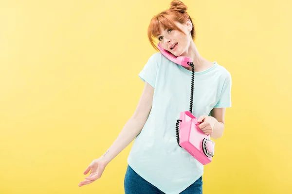Attraente rossa giovane donna parlando sul telefono retrò isolato sul giallo — Foto stock